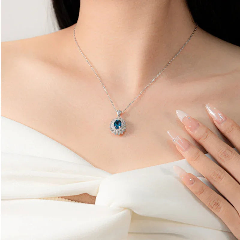 Oval blue topaz floral halo pendant necklace worn at the neckline for the November birthstone guide