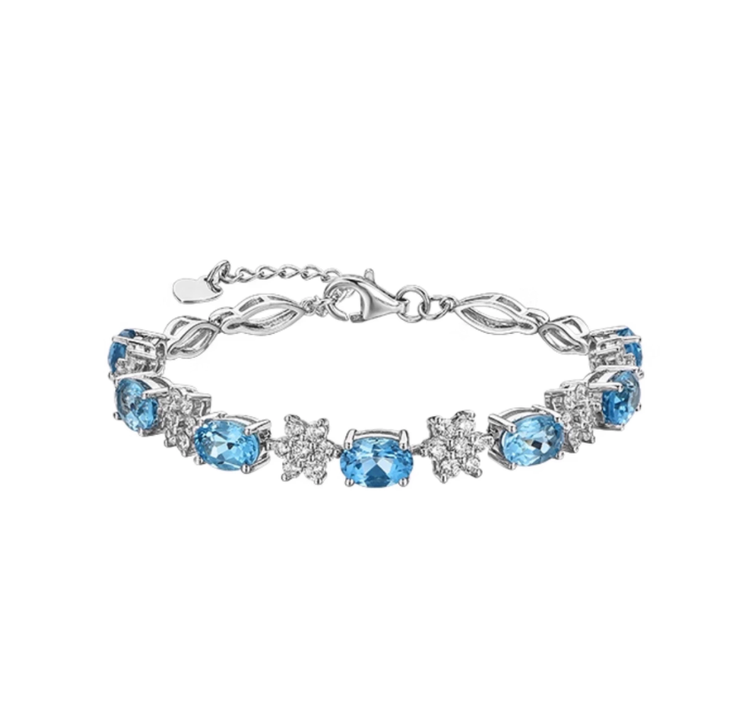 Silver-toned bracelet with alternating oval-cut vibrant blue topaz and diamond clusters. Delicate link design, perfect for stacking or adding a fresh pop of color to daily outfits.