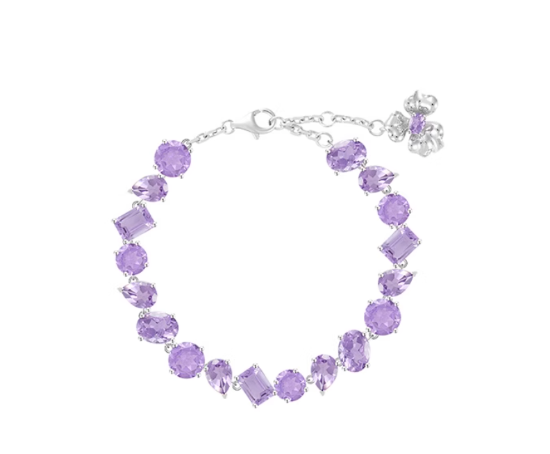 Silver-toned bracelet adorned with mixed-cut purple amethysts (round, oval, marquise, square), finished with a flower-shaped clasp. Vibrant, versatile design for daily or special occasion wear.
