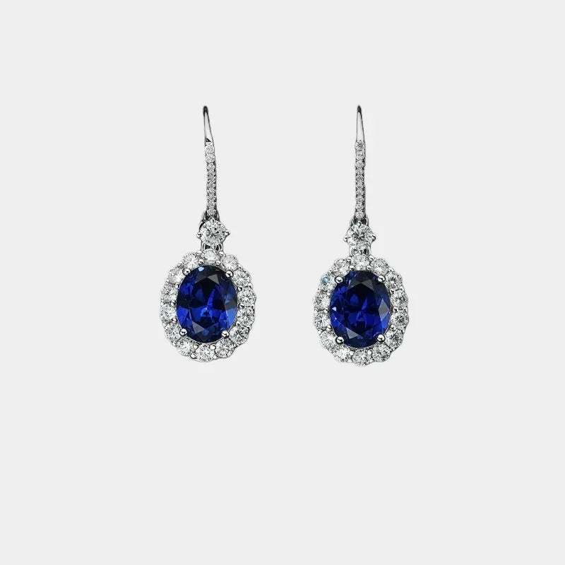 Sapphire halo hook earrings shown against a clean white background
