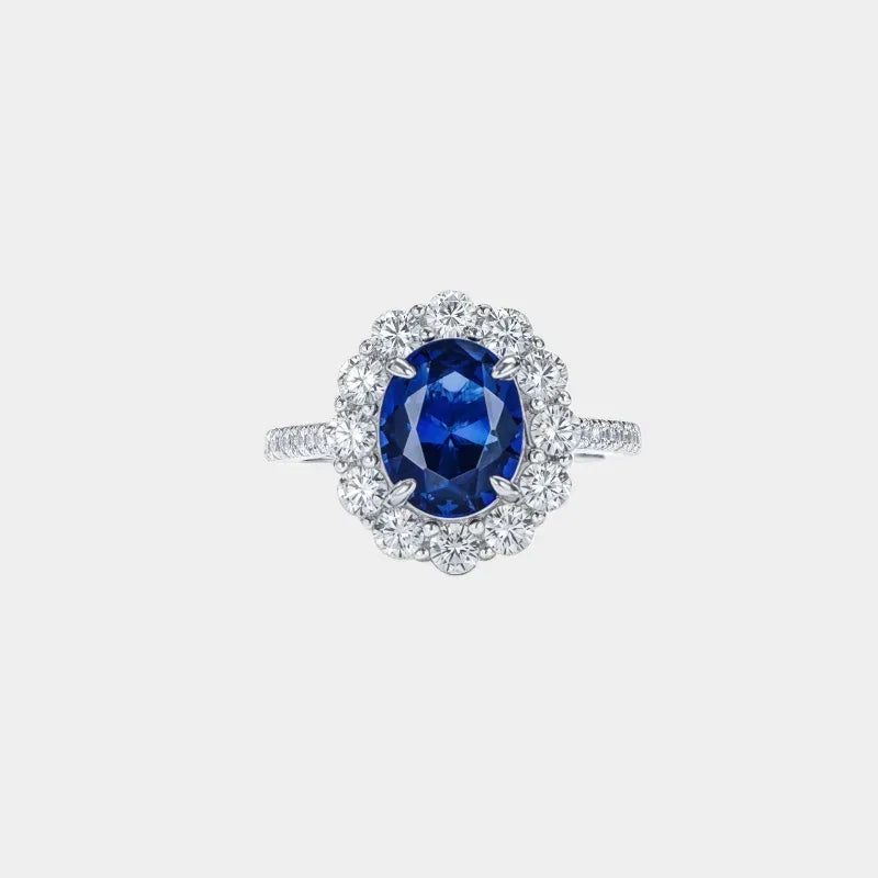 Oval sapphire halo ring shown against a clean white background
