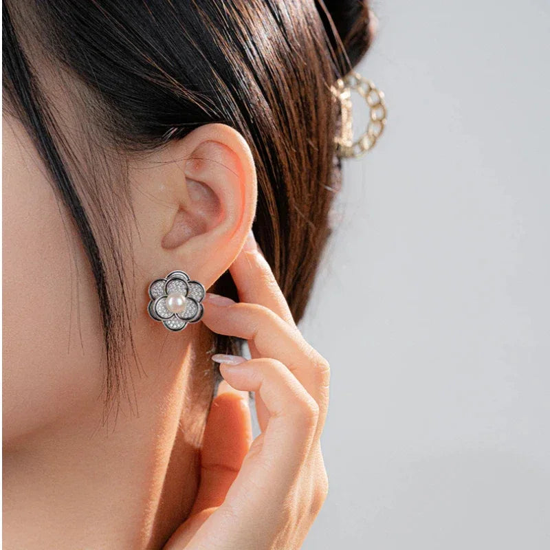 Freshwater Pearl Camellia Stud Earrings — second left-ear worn view beside a model's hand