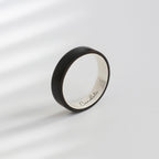 A sleek black ebony silver ring with a polished silver interior. Custom - made, it features the name "Bandetti" engraved inside. Perfect as a unique wooden wedding gift, combining elegance and personalization.