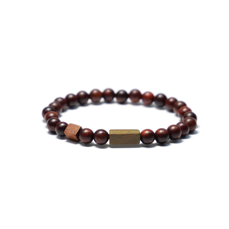 A wrist adorned with a customized bracelet made of red sandalwood and green sandalwood beads. Ideal for couples as a unique wooden wedding gift, it can be personalized for an extra special touch.