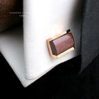 A pair of customized French shirt cufflinks with a wooden centerpiece and gold - toned metal edges, placed on a white shirt cuff. These hand - crafted cufflinks are a unique and personalized wooden wedding gift option.
