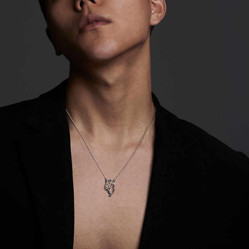 Man wearing Dali clock necklace, highlighting elegant artistry for paper wedding gifting.
