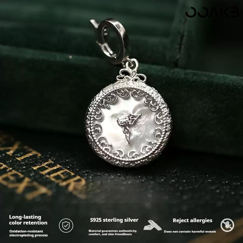 Close-up of 925 silver clock pendant with mother-of-pearl, showcasing filigree design for paper wedding.