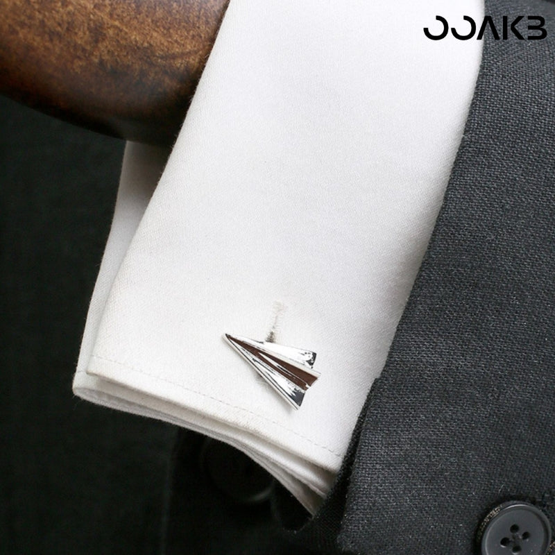 Man wearing paper plane cufflinks on French cuff shirt, perfect 1st anniversary gift.