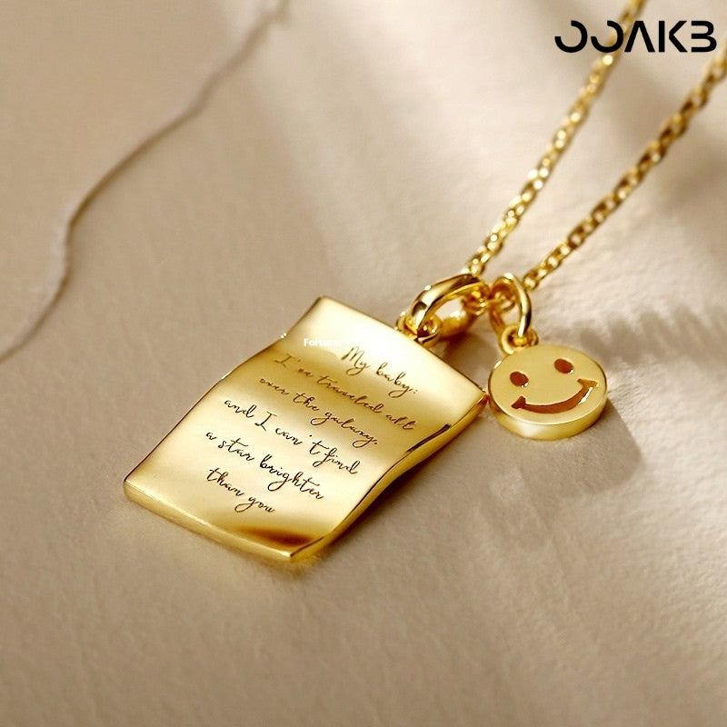Close-up of engraved love note on gold pendant, symbolizing paper wedding devotion.