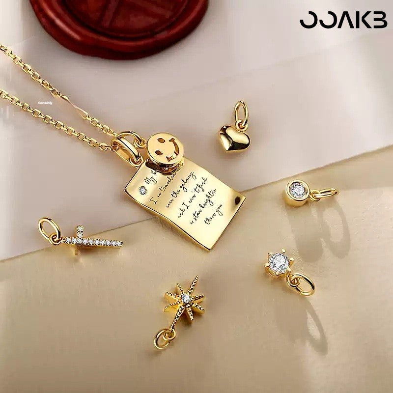 Gold love note necklace with swapable charms (heart, star) for paper wedding customization.