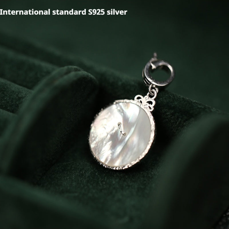 Mother-of-pearl face of 925 silver clock pendant, symbolizing timeless love for paper wedding.