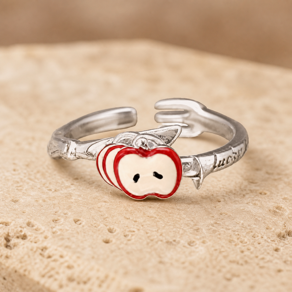 Silver-tone open ring with sculpted hands holding a red apple-slice motif on beige stone