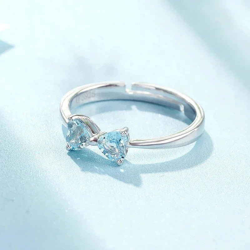 Aquamarine Bow Open Ring worn on the hand in a close-up