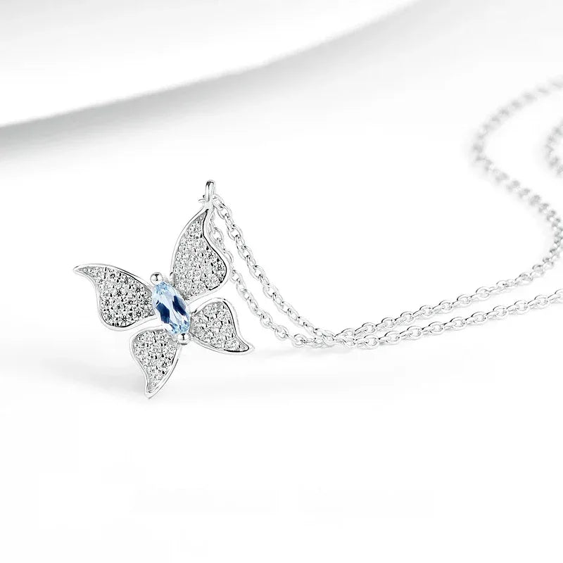 Aquamarine Butterfly Pendant Necklace pendant and chain detail on a light background