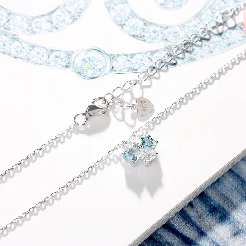 Aquamarine Four-Stone Cluster Pendant Necklace pendant and chain detail on a light background