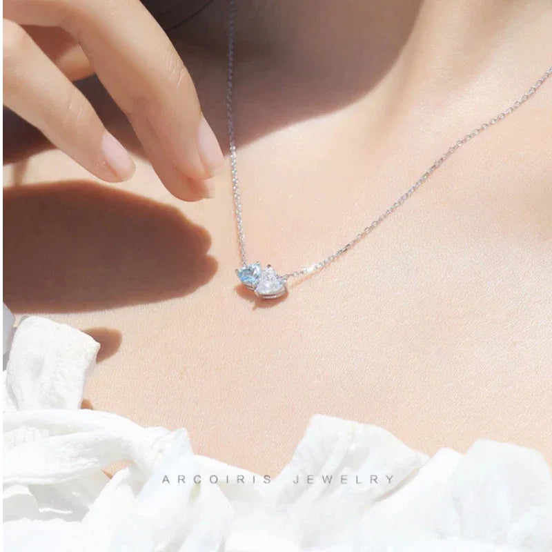 Aquamarine Two-Heart Pendant Necklace worn at the neckline in a close-up