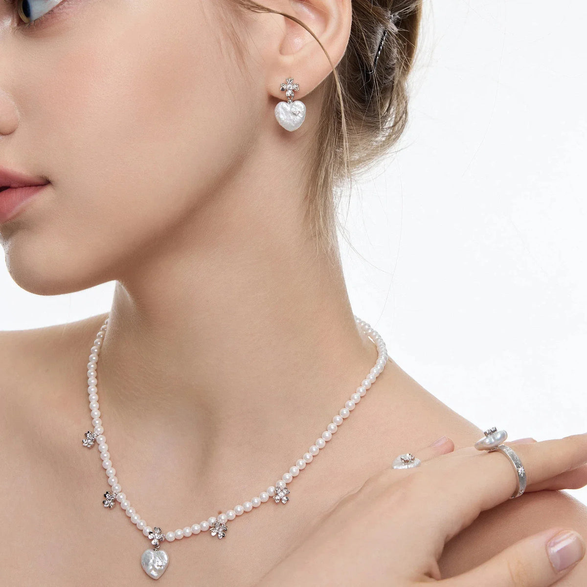 Pearl Heart Drop Earrings with Floral Tops — left-ear worn close-up