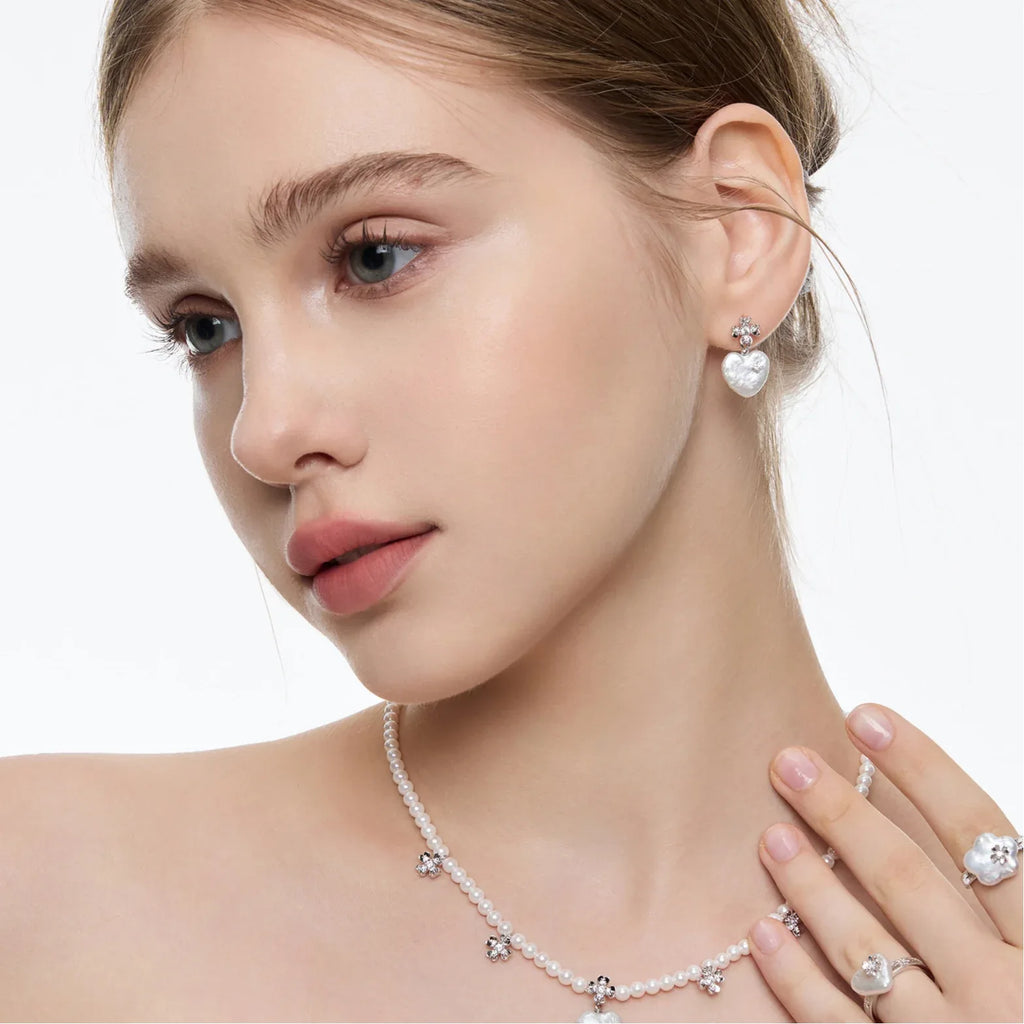 Baroque Pearl Heart Open Ring with Floral Detail — model portrait wearing the ring with matching earrings and necklace
