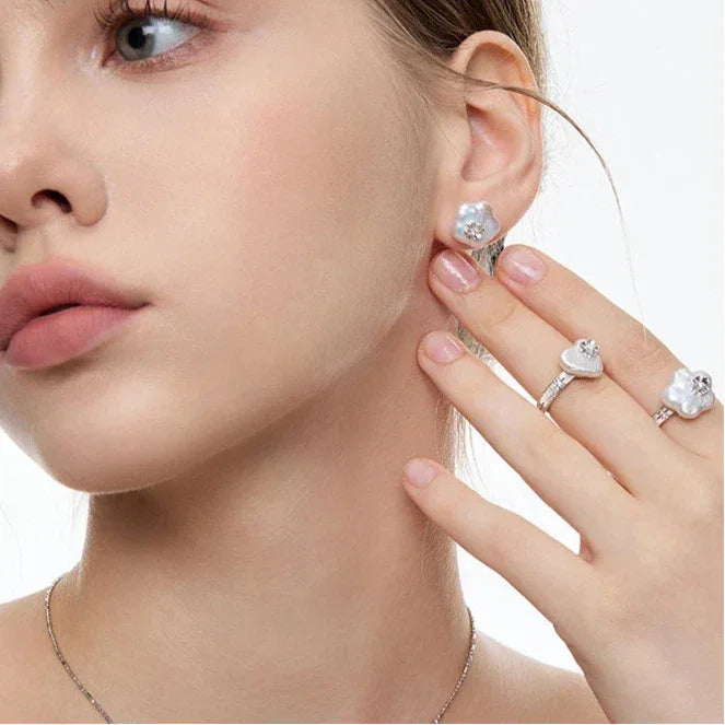 Baroque Pearl Heart Open Ring with Floral Detail — hand-worn close-up beside the model's face