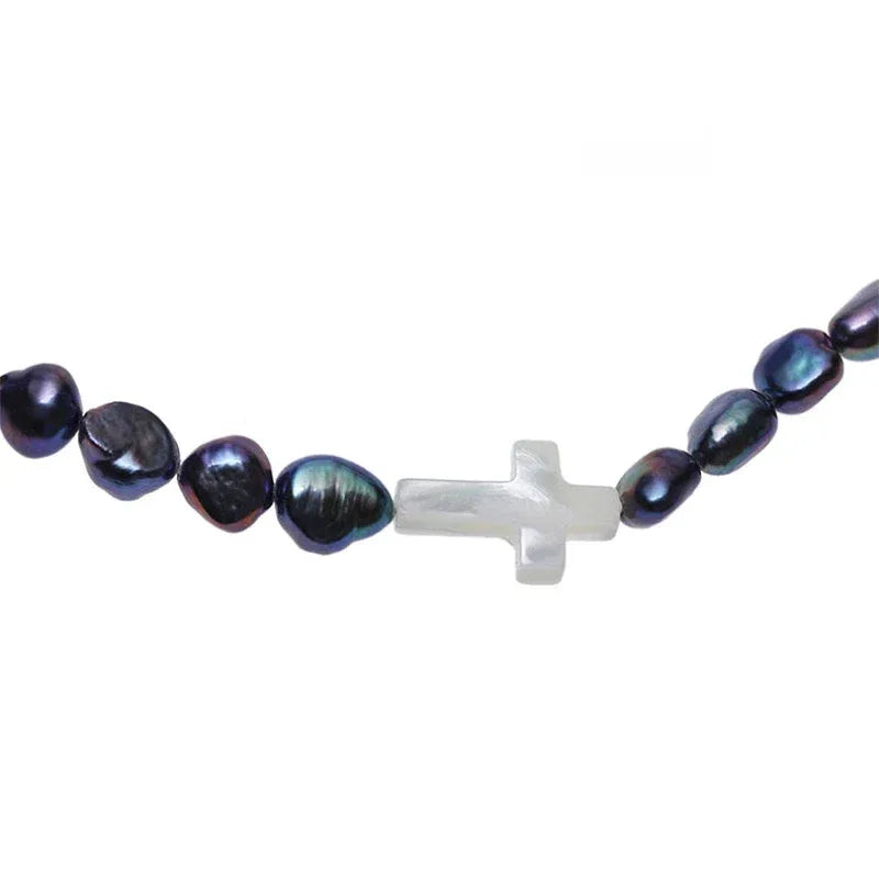 Dark Baroque Pearl Necklace with White Cross Accents — macro view of a white cross between irregular dark pearls