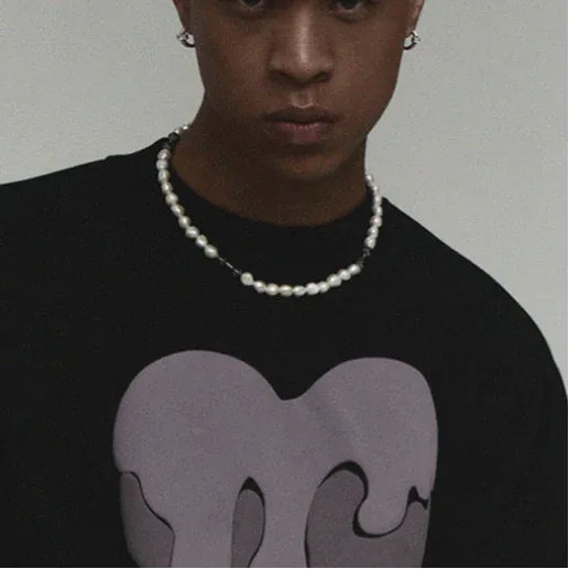 Baroque Pearl Necklace with Black Dumbbell Spacers — front neckline-worn portrait over a black graphic shirt