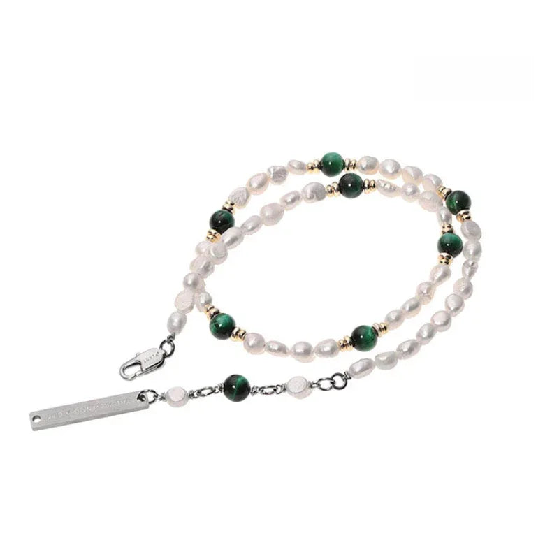 Green and White Bead Layered Necklace — necklace coiled on white showing the bar pendant