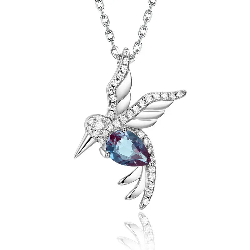 Bird-shaped pendant necklace with a Alexandrite body, close-up showing the setting and decorative accents