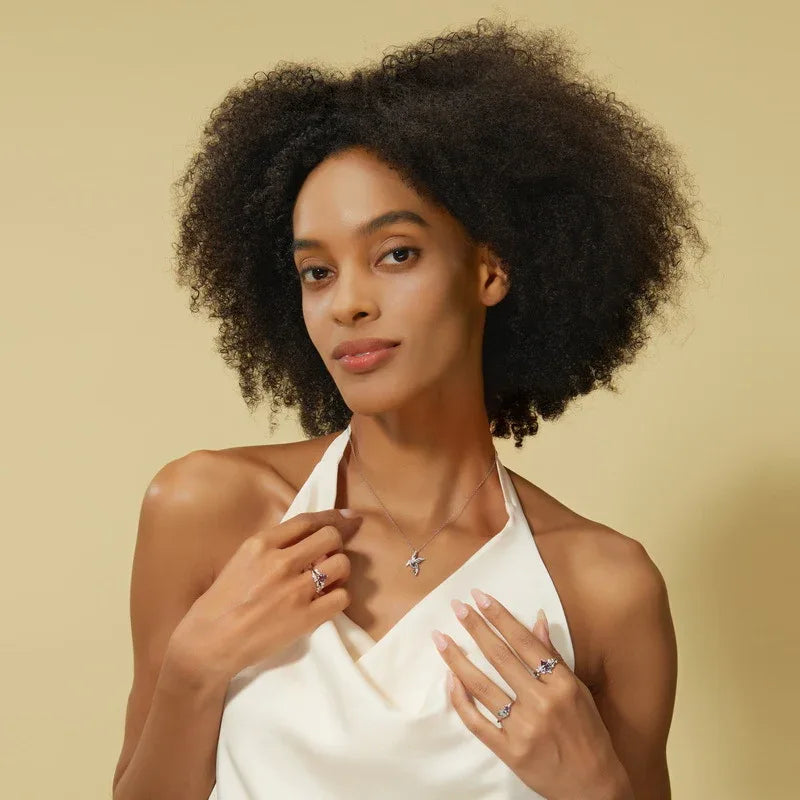 Bird-shaped pendant necklace with a Alexandrite body, shown worn by a model for scale