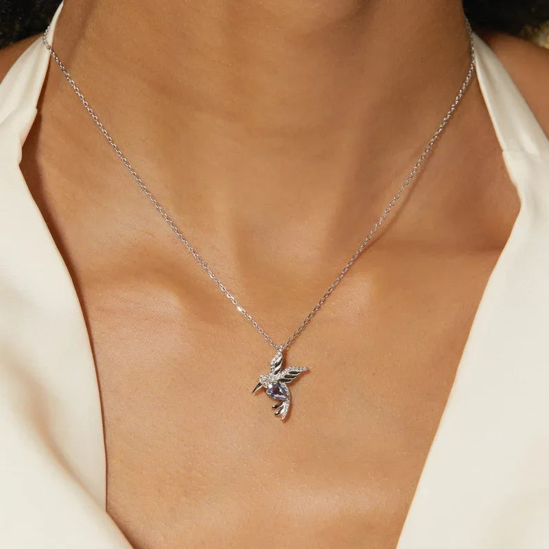 Bird-shaped pendant necklace with a Alexandrite body, shown worn in a close lifestyle view