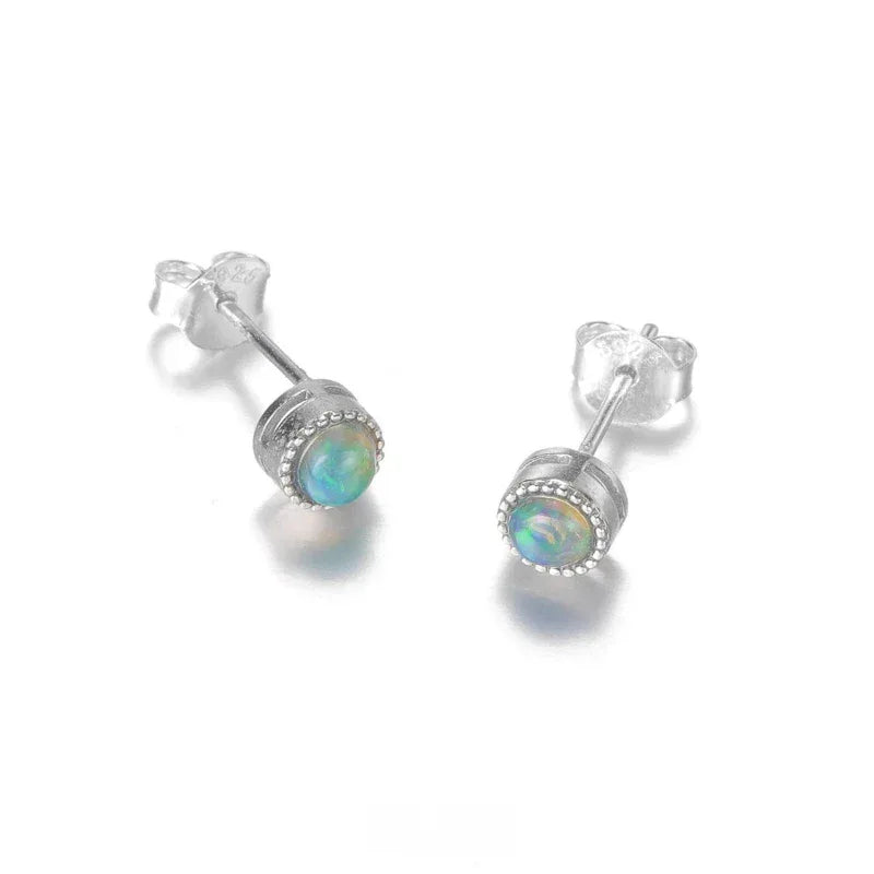 Black Opal Round Stud Earrings worn on the hand
