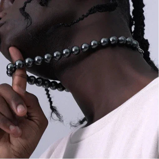 Dark Pearl Strand Necklace with Steel Clasp — model holding the necklace away from the neck