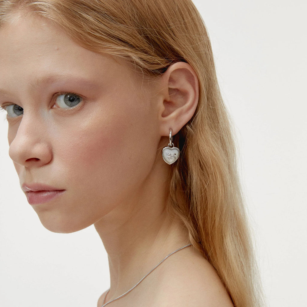 Pearl Heart Drop Earrings with Bow Detail — left-ear worn portrait