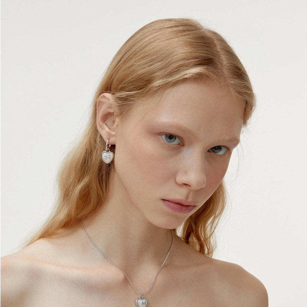 Pearl Heart Drop Earrings with Bow Detail — alternate right-ear worn view