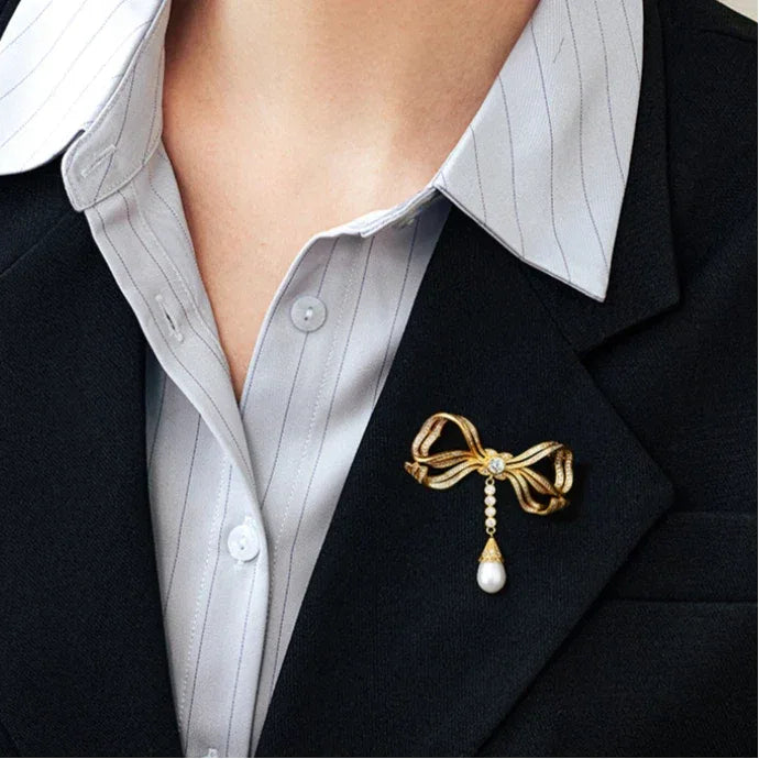 Pearl Bow Tassel Brooch — close blazer-worn view showing the full hanging pearl