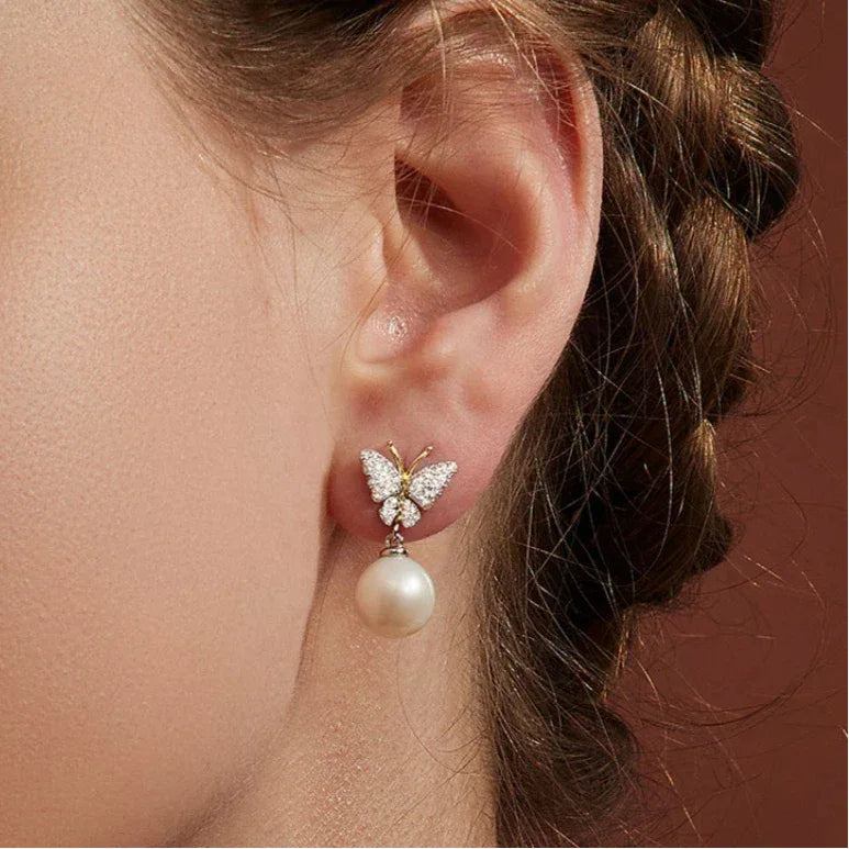 Butterfly Pearl Drop Earrings in Platinum-Plated S925 Silver — close left-ear worn view showing the butterfly and pearl drop