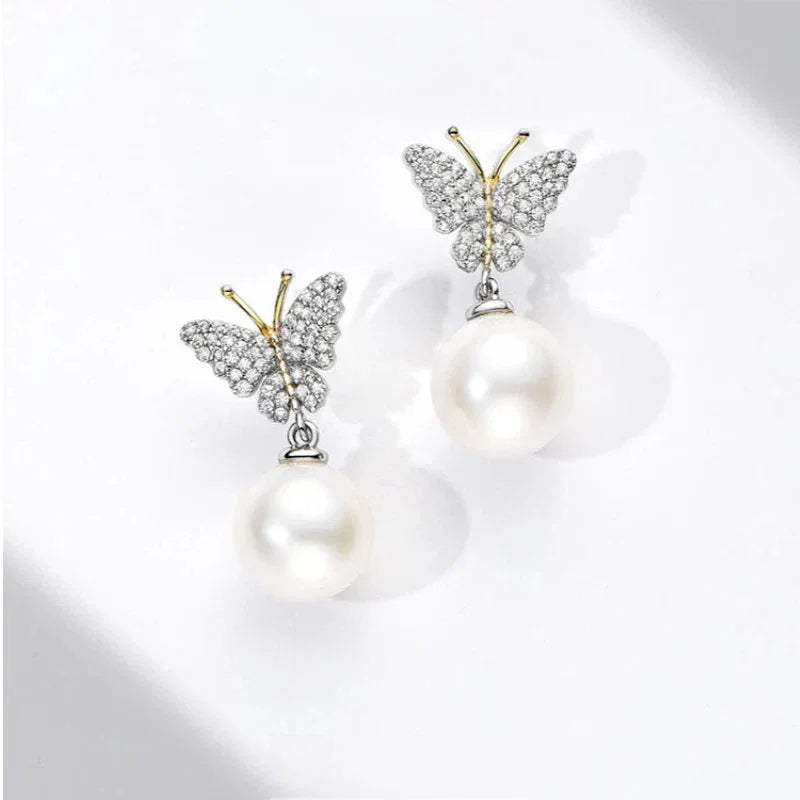 Butterfly Pearl Drop Earrings in Platinum-Plated S925 Silver — angled pair on white