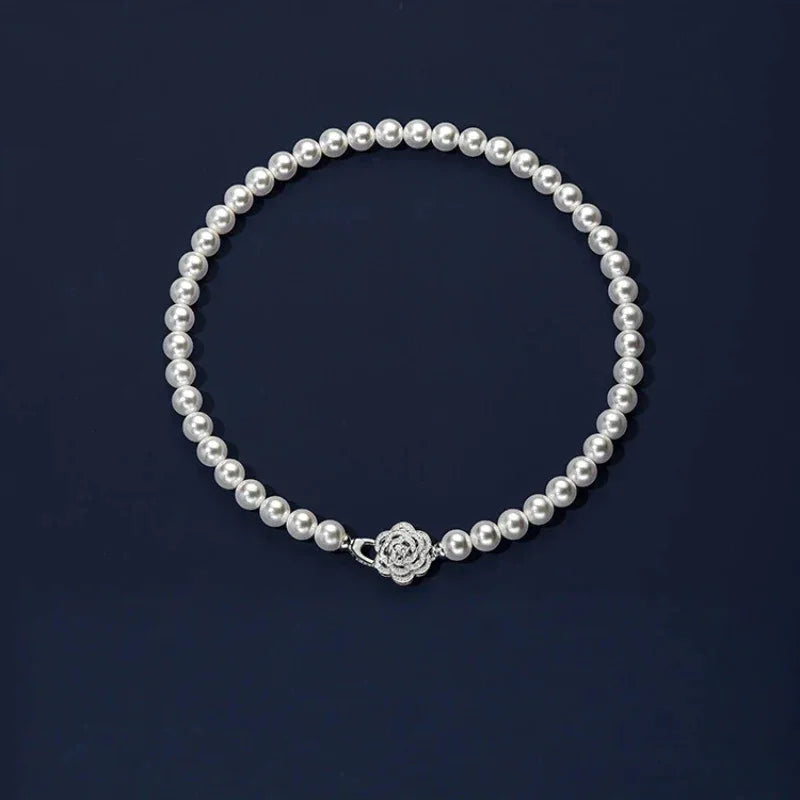 Pearl Strand Necklace with Camellia Clasp — full necklace displayed on a dark background