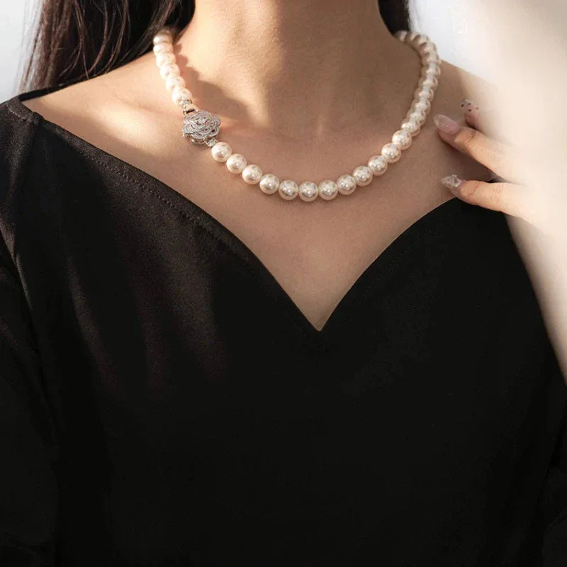 Pearl Strand Necklace with Camellia Clasp — necklace worn at the neckline with the flower clasp centered