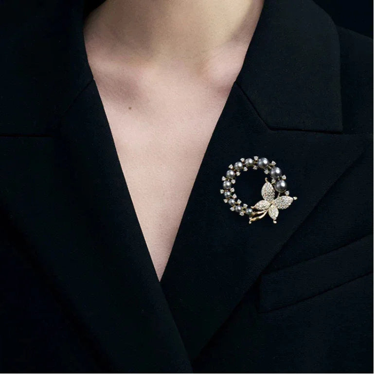 Dark Pearl Butterfly Wreath Brooch — close black-blazer worn view showing the open wreath center