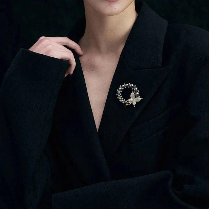 Dark Pearl Butterfly Wreath Brooch — model portrait with the brooch pinned on a black blazer
