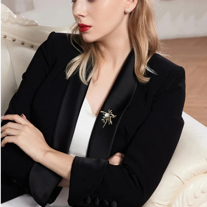 Shell Pearl Bow Brooch — seated model wearing the brooch on a dark blazer