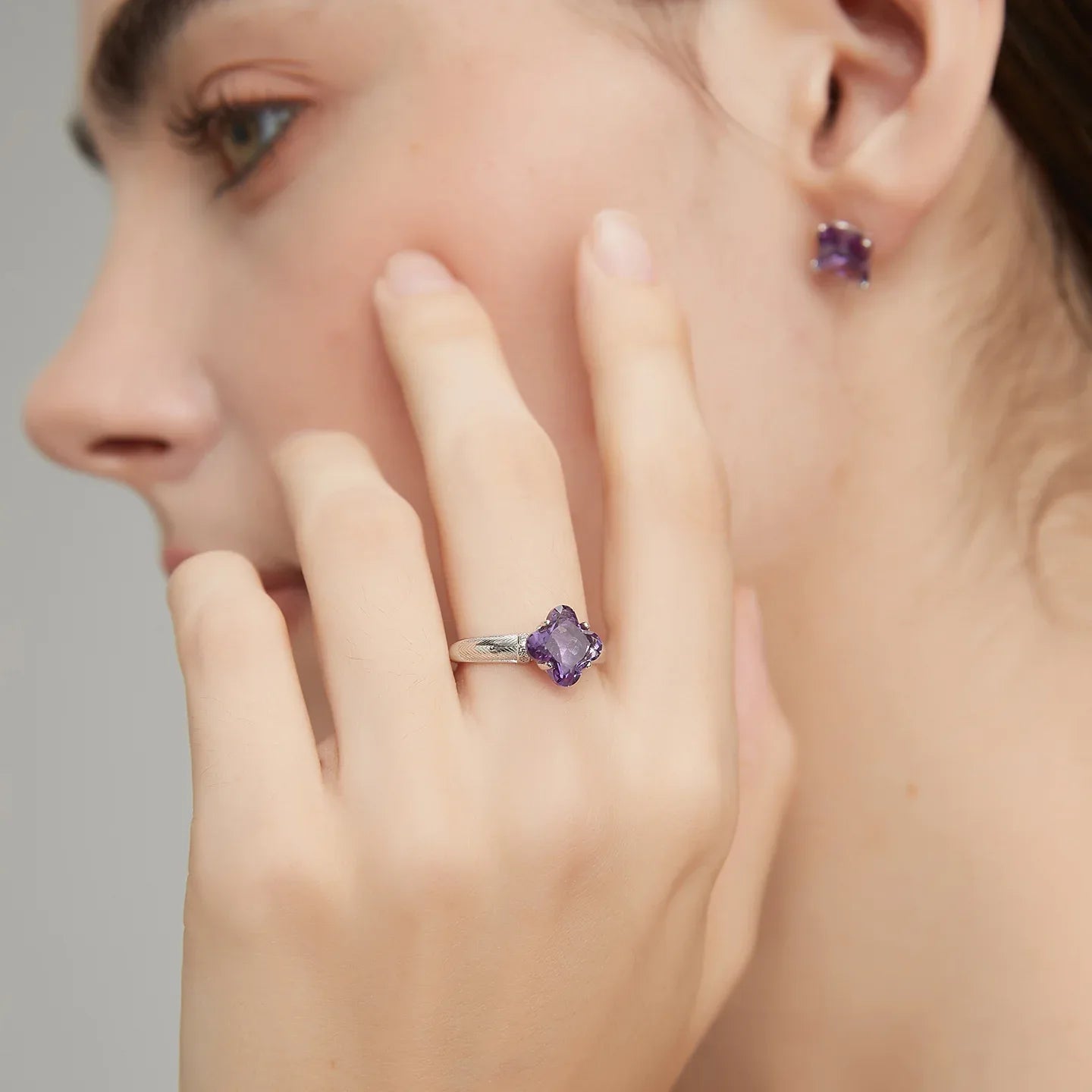 clover-cut amethyst ring worn on the hand in a close-up