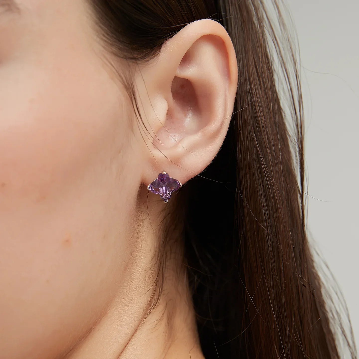 clover-cut amethyst stud earrings styled portrait showing the earrings for scale