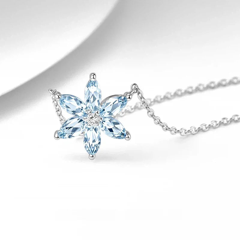 Eight-Point Aquamarine Snowflake Pendant Necklace pendant and chain detail on a light background