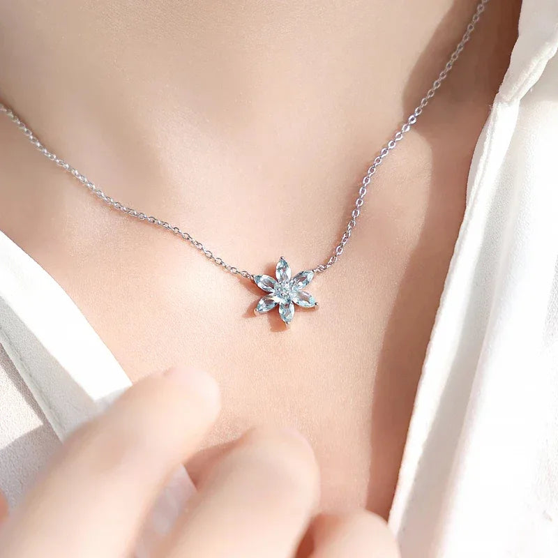 Eight-Point Aquamarine Snowflake Pendant Necklace worn at the neckline in a close-up