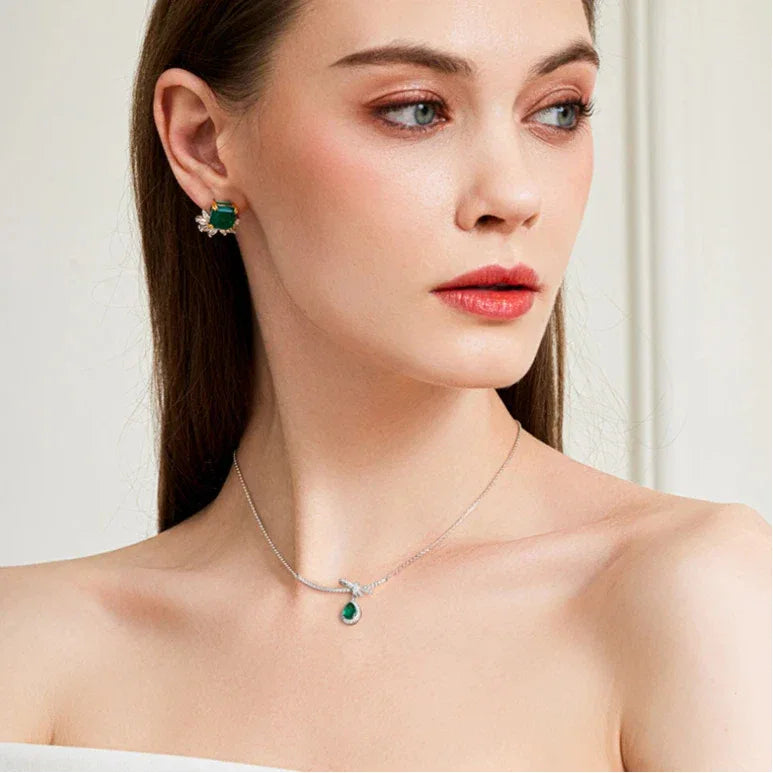 Emerald Bow and Pear Drop Necklace worn at the neckline in a close-up