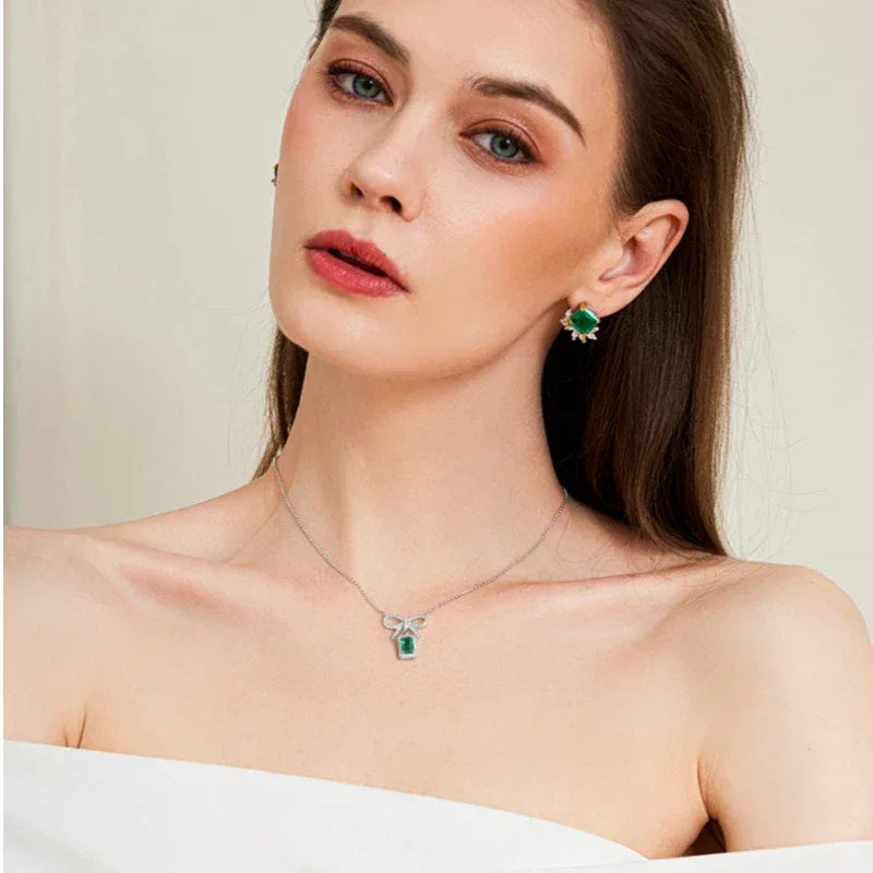 Emerald Bow Pendant Necklace worn at the neckline in a close-up