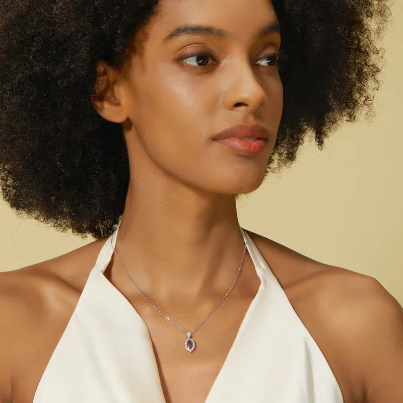 Emerald-cut Alexandrite halo pendant necklace, shown worn by a model for scale