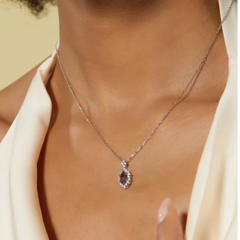 Emerald-cut Alexandrite halo pendant necklace, shown worn in a close lifestyle view