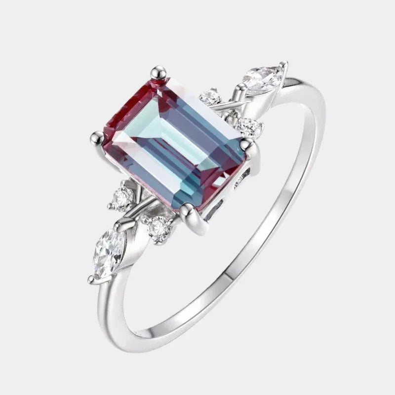 Emerald-cut Alexandrite ring with leaf side accents, front product view on a white background